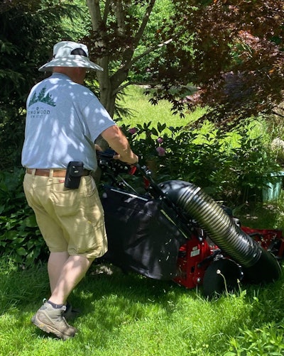 Paul Rubacky cutting grass with a walk behind mower