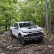 2023 Chevy Silverado ZR2 Bison white parked in woods on trail surrounded by trees