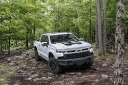 2023 Chevy Silverado ZR2 Bison white parked in woods on trail surrounded by trees