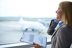 Woman on the phone holding a clipboard with graphs