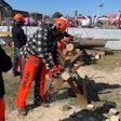 man dressed in echo safety gear while using an echo chainsaw to cut through a log