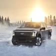 Ford F-150 Lightning Alaska in snow with trees and the sun in the background