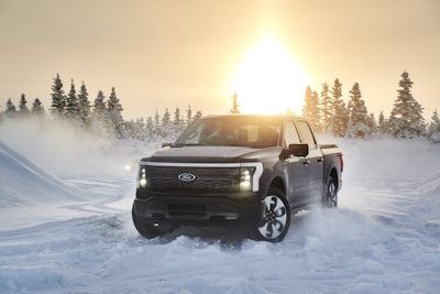 Ford F-150 Lightning Alaska in snow with trees and the sun in the background