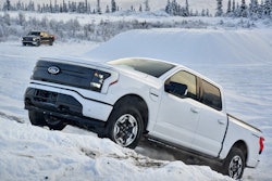 white Ford F-150 Lightning driving up snow bank