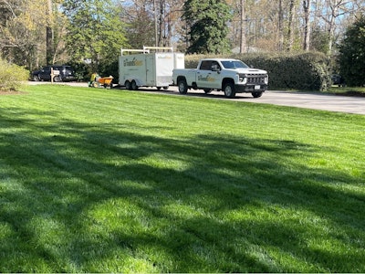 Grounds Guys Truck parked by a freshly cut lawn