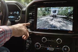 man's finger touching dial on dashboard camera showing Ford's new Pro Trailer Hitch Assist