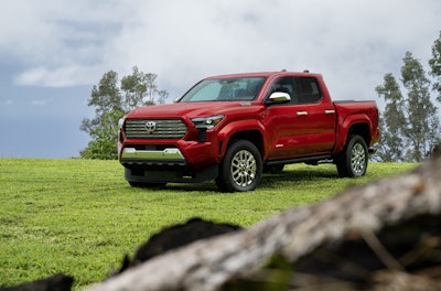 red 2024 Toyota Tacoma Limited on green grass mountain top