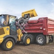 John Deere 244 P-Tier compact wheel loader dumping load.