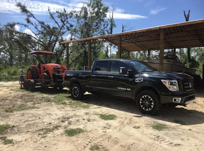 2019 Titan XD diesel hitched to trailer carrying tractor