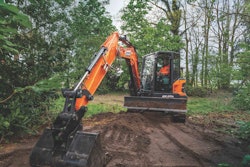 DEVELON DX62R-7 compact excavator digging in woods