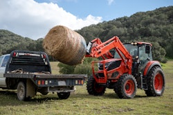 kioti hx series tractor loading a bale of hay