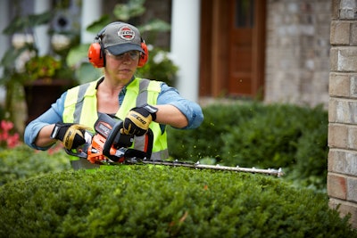 woman using hedge trimmer