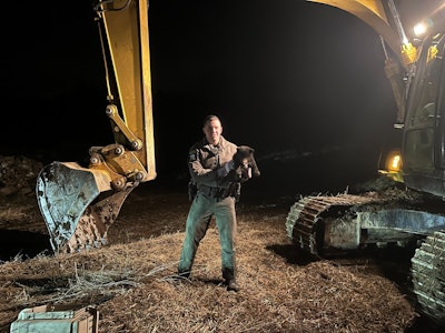 ECO Jarecki holds a bear cub rescued from an excavator cab