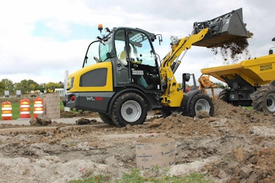 Wacker Neuson WL38 small articulated loader dumping dirt in back of dumper