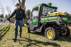 woman spraying fence next to new gator UTV