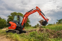 Kubota KX040-5 mini excavator digging in field