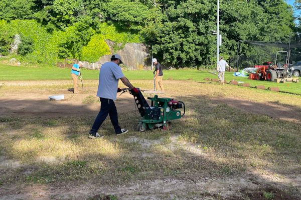 Volunteers from the New England Sports Field Management Association work to restore the baseball field at the Yawkey Boys & Girls Club of Roxbury. Sports field professionals donated their time, expertise, and equipment to transform the aging field as part of Project EverGreen's GreenCare for Communities initiative.